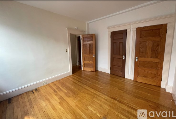 A room with wooden floors and two doors.
