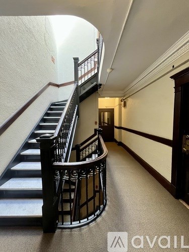 A staircase with a metal railing and a carpeted floor.