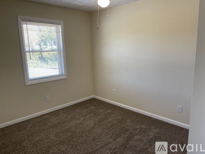 A room with a carpeted floor and a window.