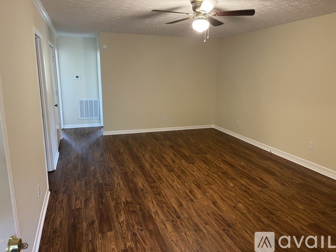 A room with wooden flooring and a ceiling fan.