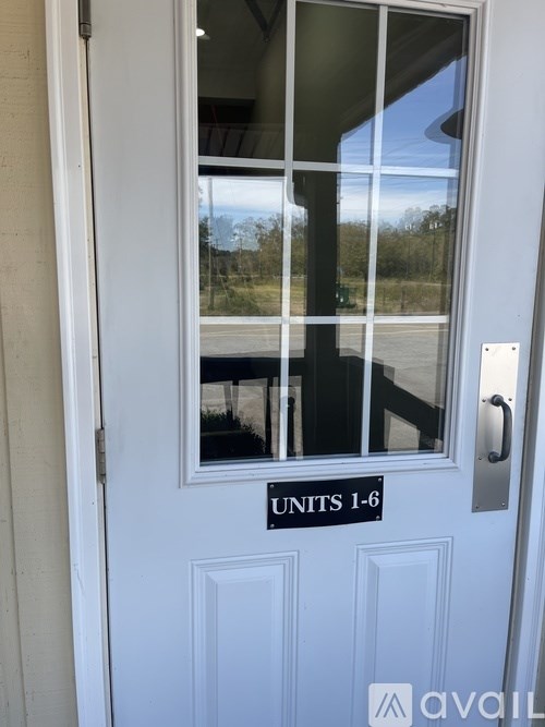 A white door with a glass window and a sign that says "UNITS 1-6".