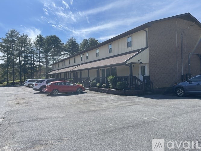 A parking lot with cars and a building in the background.