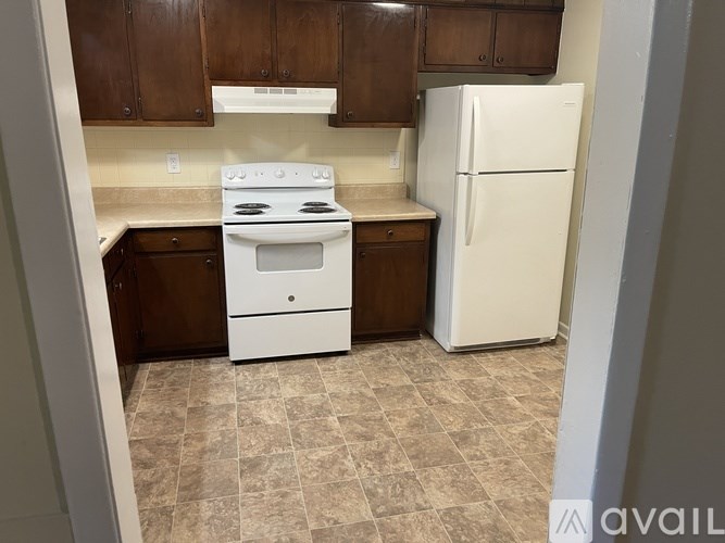 A kitchen with a white stove and refrigerator.