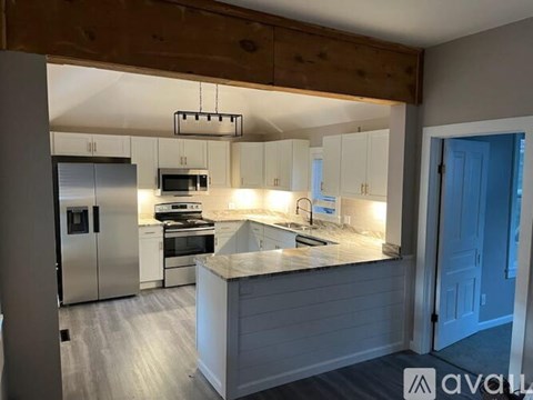 A kitchen with a wooden ceiling and stainless steel appliances.