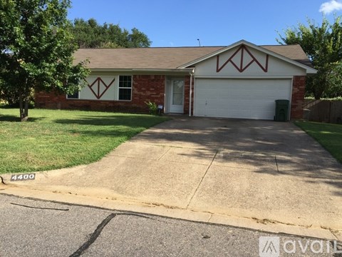 A house with a garage and a driveway in front.