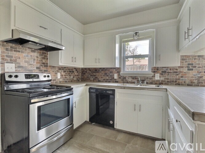 A kitchen with a stove top oven and a black dishwasher.