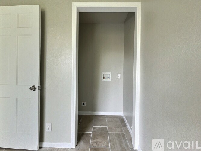 A white door is open to a hallway with tiled flooring.