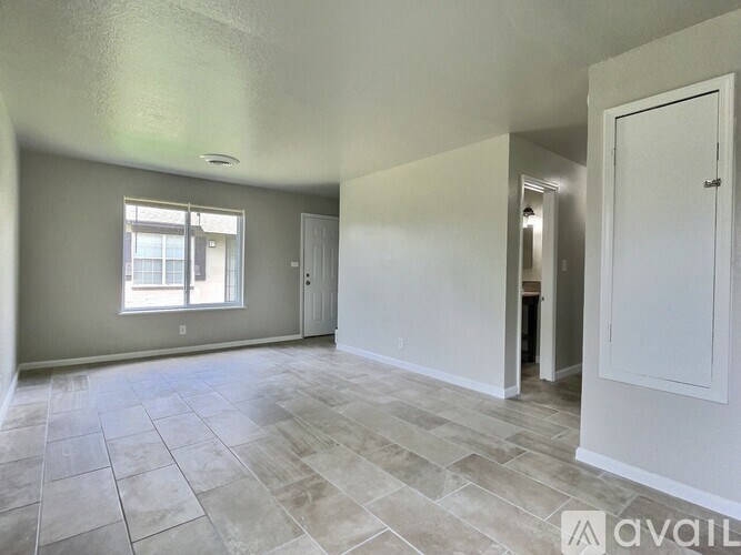A spacious room with tile flooring and a window.