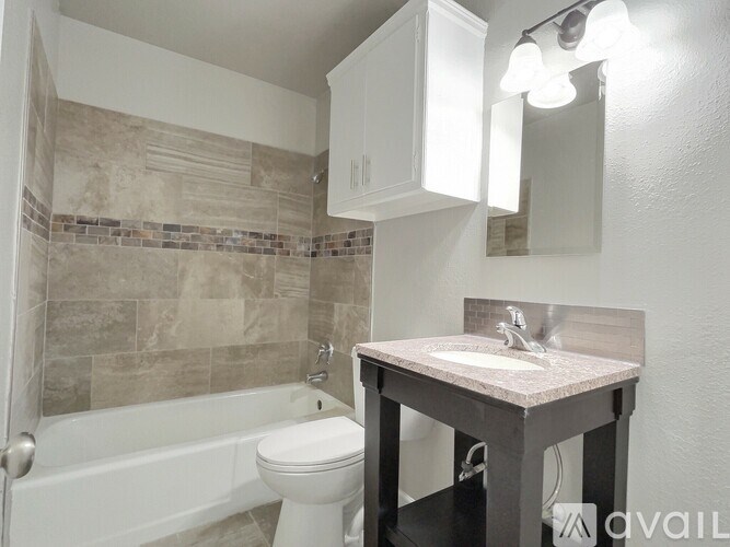 A bathroom with a toilet, sink, and a mirror.