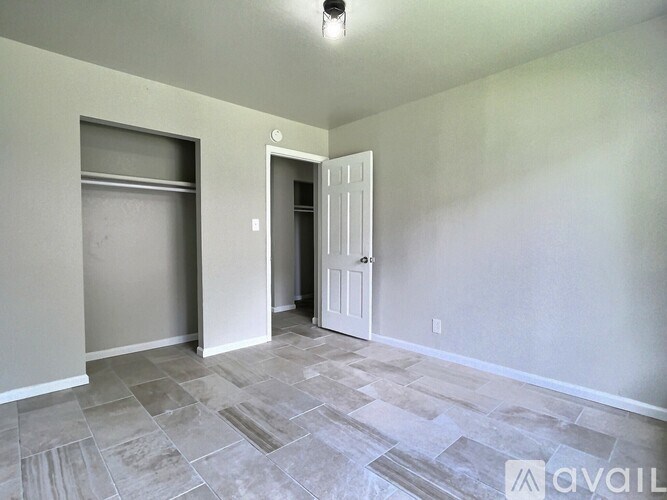 A room with a tiled floor and a door on the right.