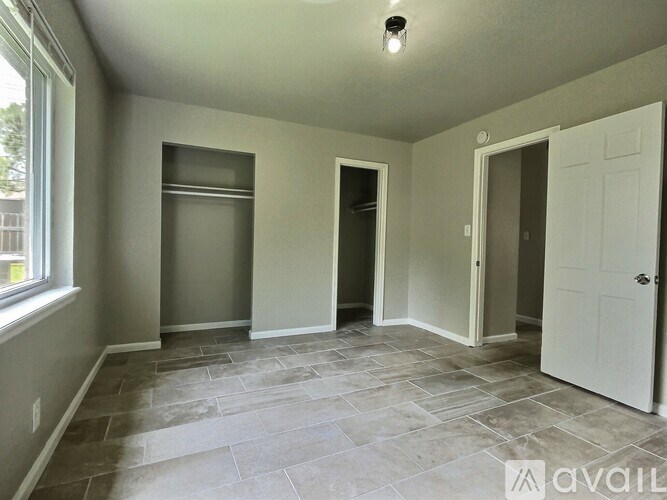 A room with a stone floor and a window on the left side.
