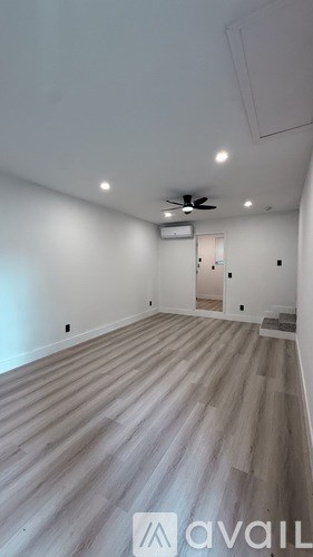 A room with a wooden floor and a ceiling fan.