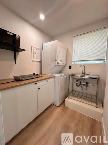 A small kitchen with white cabinets and a wooden countertop.