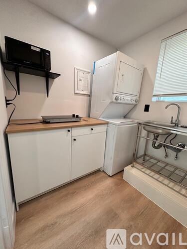 A small kitchen with a microwave, oven, and sink.