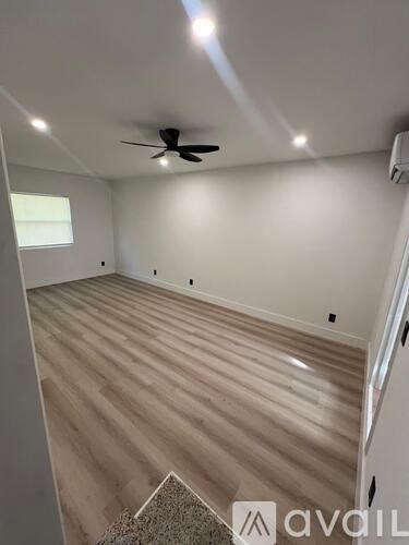 A room with a ceiling fan and wooden flooring.