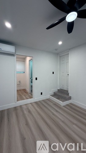 A room with a ceiling fan and wooden flooring.