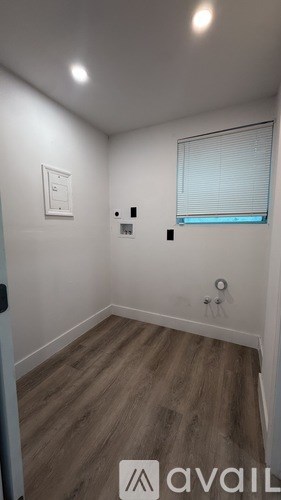 A room with a window and a light switch on the wall.