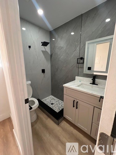 A bathroom with a toilet, sink, and a walk-in shower.