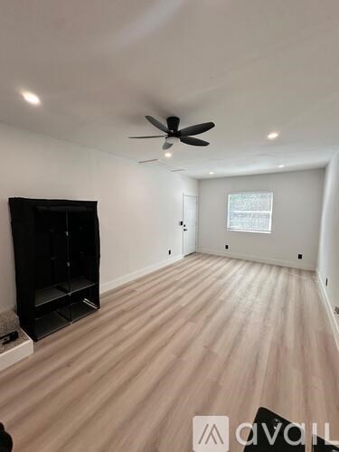 A room with a ceiling fan and wooden flooring.