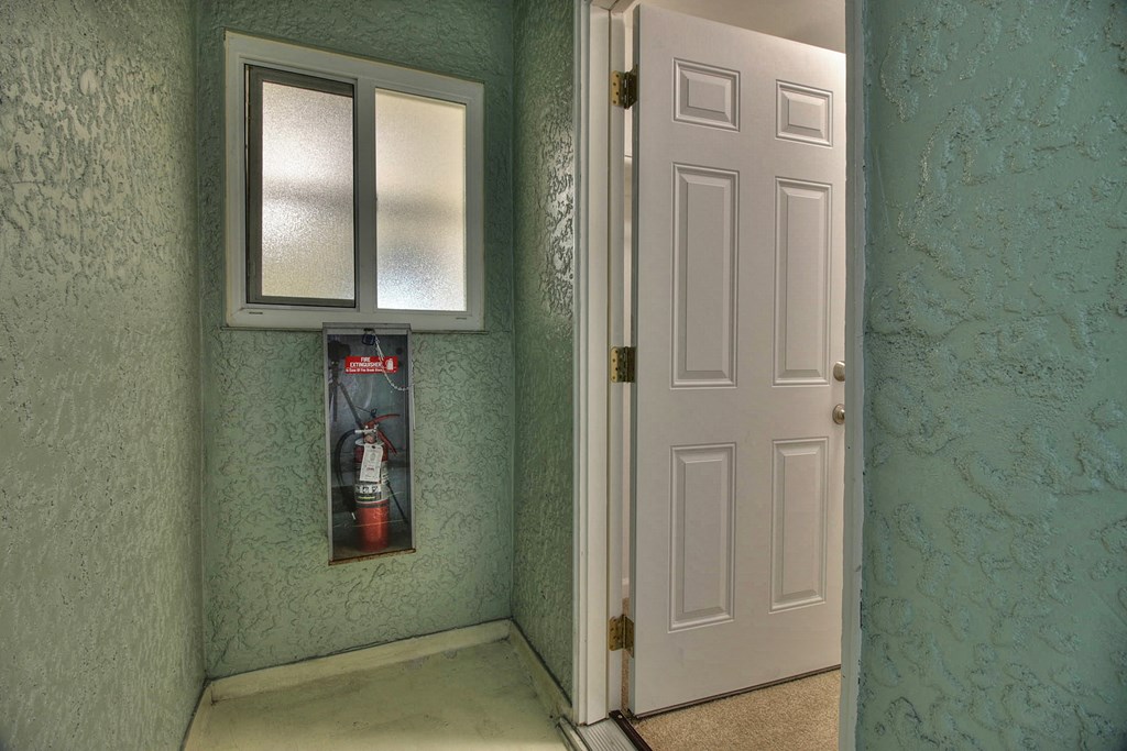 a room with a door and a window and a medicine cabinet