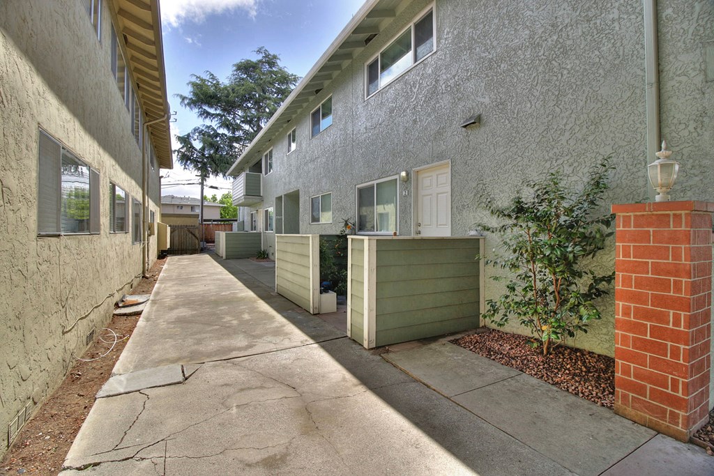 an empty sidewalk in front of an apartment building