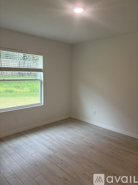 A room with a window and wooden flooring.