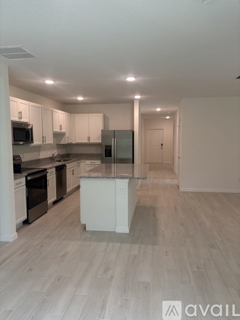 A kitchen with a white island in the middle of the room.