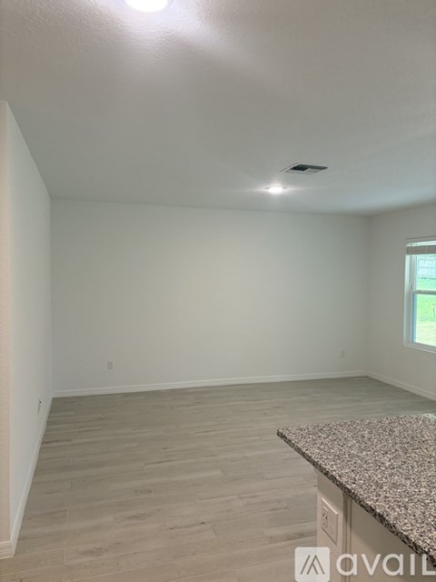A room with a granite countertop and wooden flooring.