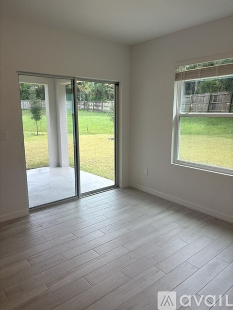 A room with a sliding glass door leading to a backyard.