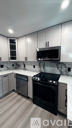 A modern kitchen with a black oven and stove top.