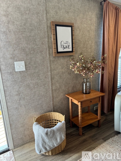 A room with a table, a basket, and a vase with flowers.