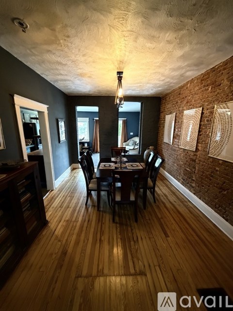 A dining room with a wooden table and chairs.