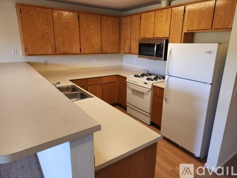 A kitchen with wooden cabinets and white appliances.