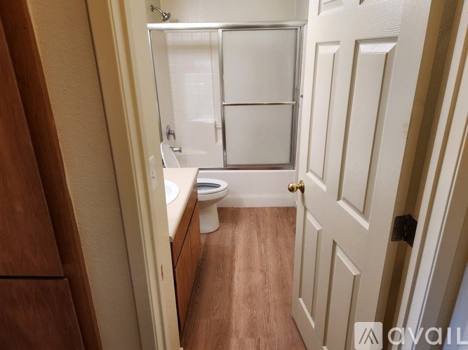 A small bathroom with a toilet, sink, and shower.