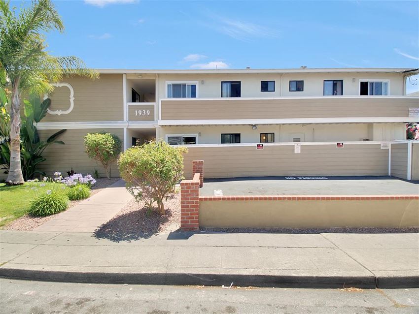the front of an apartment building with a sidewalk in front of it