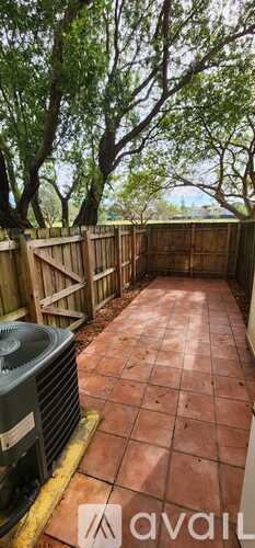 A patio with a tiled floor and a heat pump unit.