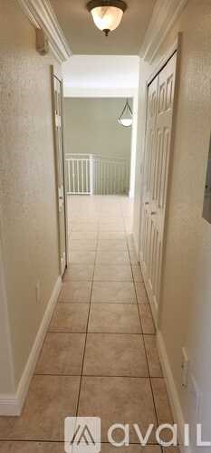 A hallway with tiled floors and white walls.