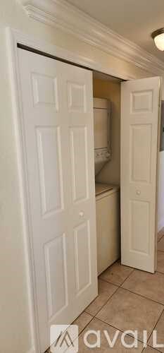 A white door is open to reveal a small bathroom.