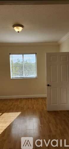 A room with a white door and a window with blinds.