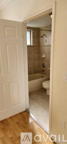 A bathroom with a tub, toilet, and sink.