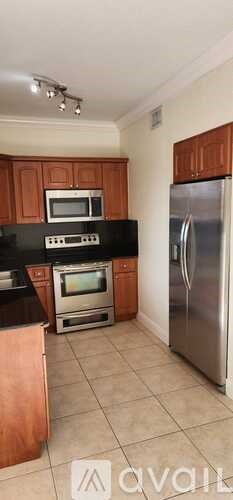 A kitchen with wooden cabinets and a black countertop.