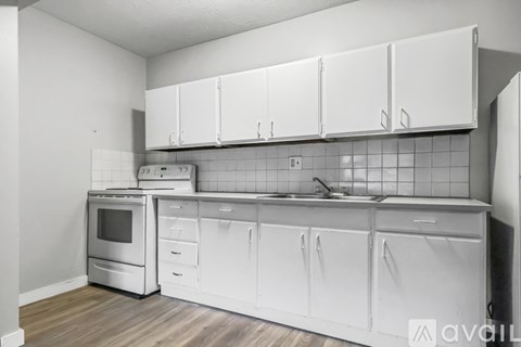 A kitchen with white cabinets and appliances.