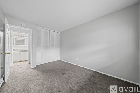 A room with white walls and a grey carpet is available for rent.