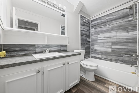 A bathroom with a sink, toilet, and a shower with a glass door.