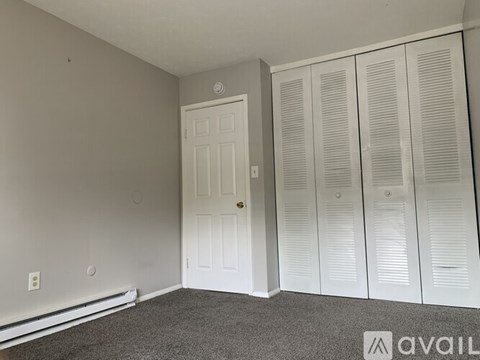 A room with a white door and three white closets.