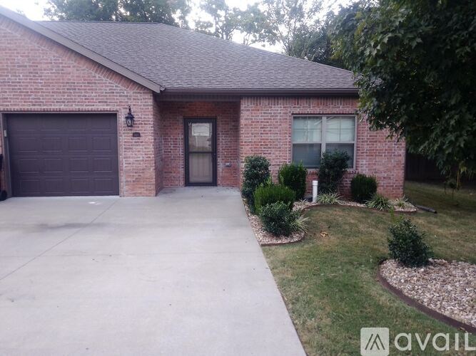 A brick house with a garage door and a driveway.