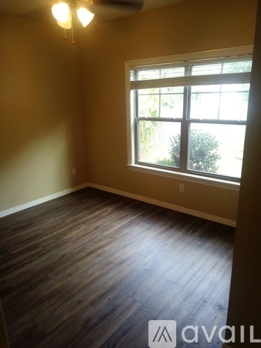 A room with a window and wooden flooring.