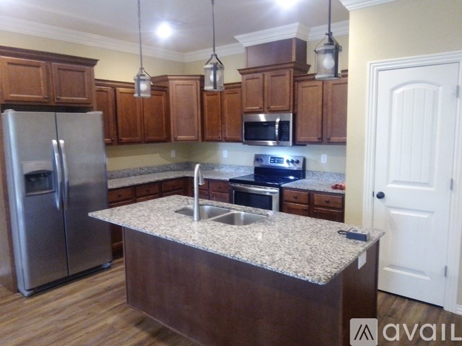 A kitchen with a granite countertop and stainless steel appliances.