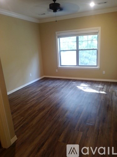 A room with wooden flooring and a window.