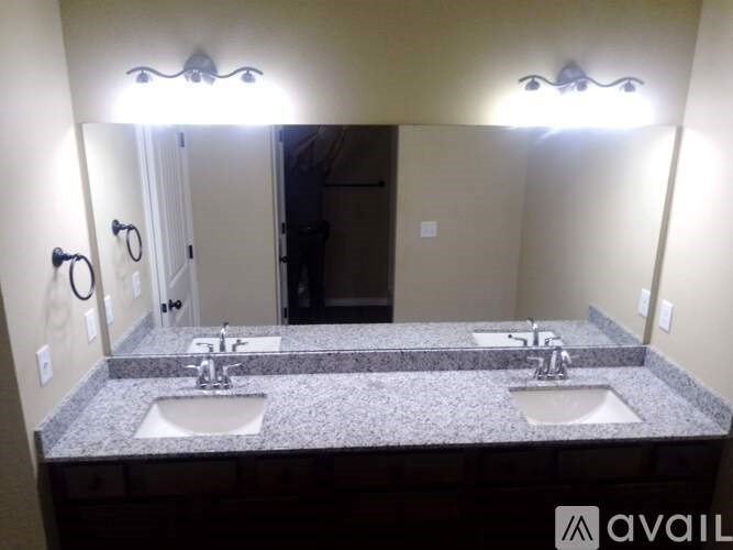 A bathroom with two sinks and a large mirror.